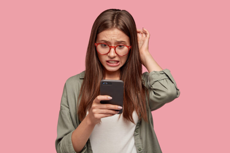 Menina confusa com celular na mão